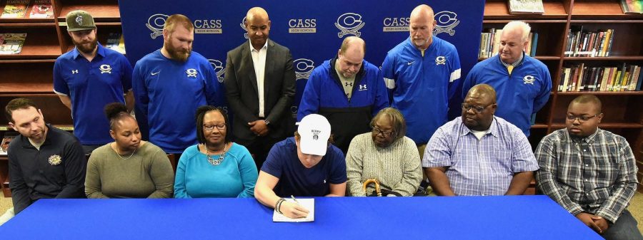 RANDY PARKER/THE DAILY TRIBUNE NEWS Cass High School senior J.P. Perry signed Wednesday to play football at Berry College in Rome. On hand for the signing were, front row, from left: Adam Jernigan, rec. coach; Jackie Cox, aunt; Geri Perry, mother; Sarah Cox, grandmother; Dennis Cox, uncle; and Zach Taylor, cousin.  Back row: P.J. Hughes and Brock Pyle, CHS assistant coaches; Richard Cox, cousin and mentor; Bobby Hughes, CHS head football coach; Jamey Gaddy, CHS assistant coach; and Dr. Nicky Moore, CHS athletic director.